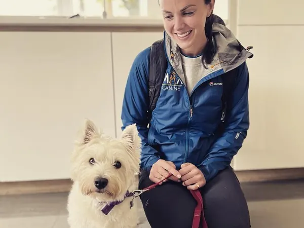 Emily with a West Highland terrier on a lead indoors